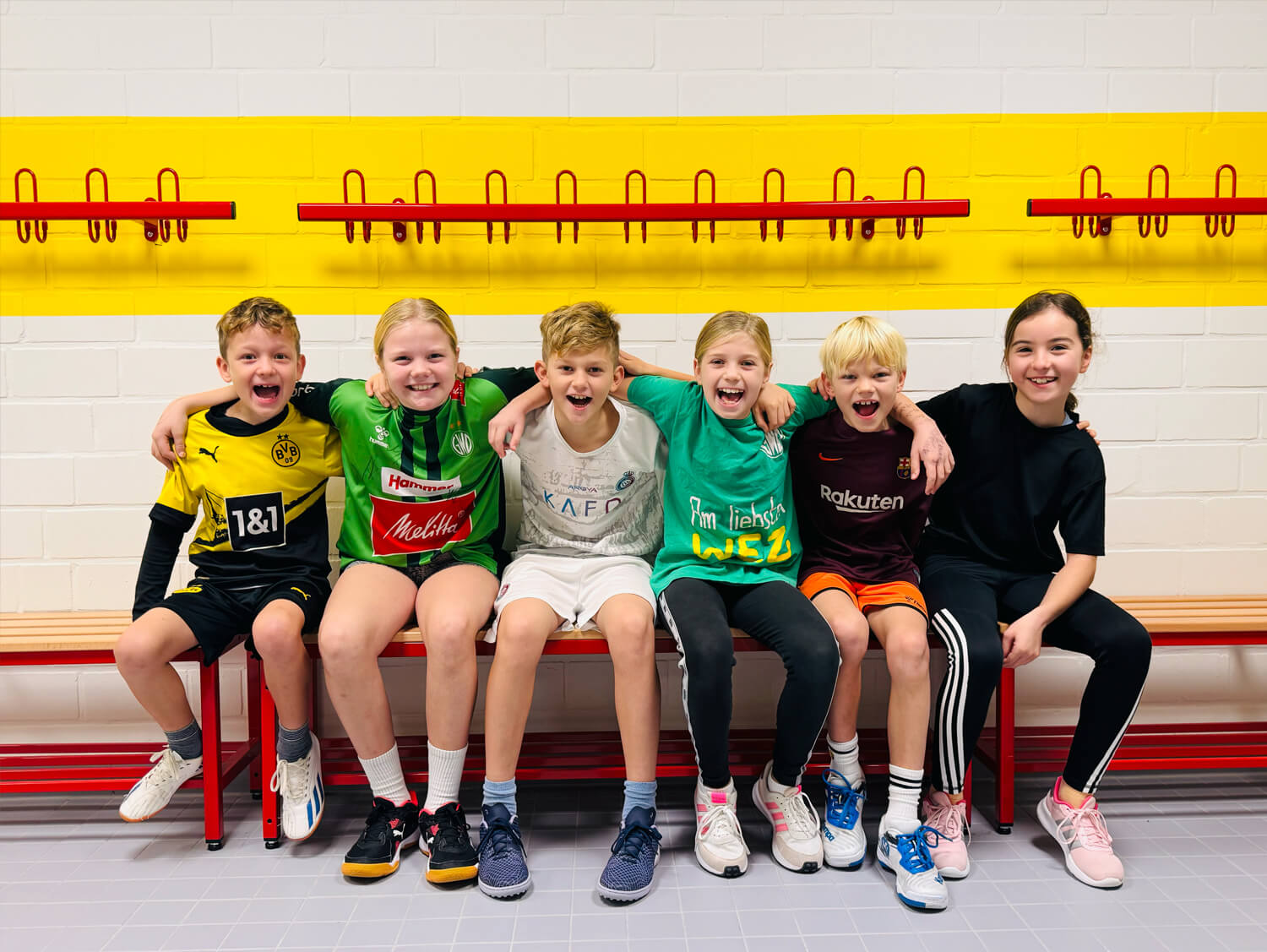 6 kinder sitzen in der umkleidekabine als gruppe
